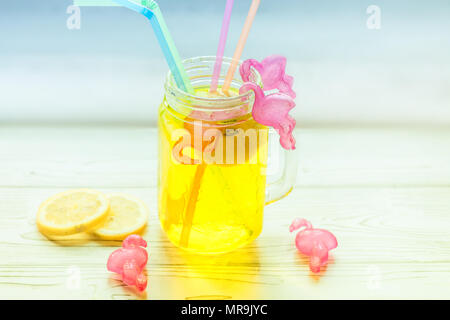 Ice cold Lemonade in glass jar with straws and icy plastic flamingos Stock Photo