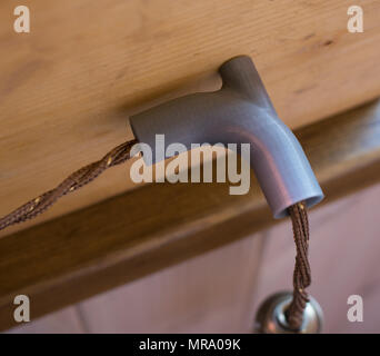 Vintage wire cable plastic holder on the wooden wall Stock Photo