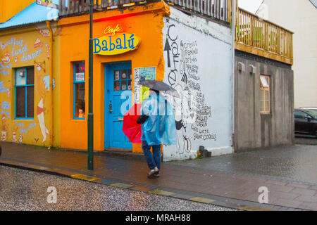 Laugavegur, Reykjavík, Iceland. 26/05/2018. Yellow warning for bad weather on the island as tourists from cruise ships and foreign holidaymakers visit the shops, in the tourist section of the city centre. A day of windy, persistent continuing heavy rain is forecast. Credit: MediaWorldImages/AlamyLiveNews. Stock Photo