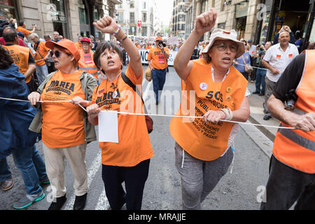 Barcelona, Catalonia, Spain. 26th May, 2018. Three woman wearing orange vests rising their fist during the demonstration.Hundreds or people rally in the streets of barcelona claiming for descent pensions. The movement named 'Marea Pensionista'' called for the demonstration and marched from Cathedral Square to Sant Jaume Square Credit: Freddy Davies/SOPA Images/ZUMA Wire/Alamy Live News Stock Photo