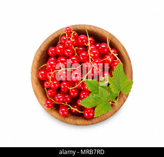 Redcurrant in a wooden bowl. Top view. Ripe and tasty currant isolated on white background. Red berries with leaves. Stock Photo