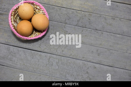 three eggs and nest on gray background Stock Photo