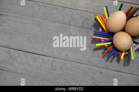 three eggs and sticks on gray background Stock Photo