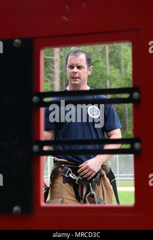 Staff Sgt. Joshua Linder, a 125th Civil Engineering Squadron firefighter, conducts forcible entry training at Naval Air Station Jacksonville, Fla., June 2, 2017. Forcible entry is a method of gaining access via halligan bars, axes, or sledgehammers. (U.S. Air National Guard photo by Staff Sgt. Carlynne DeVine) Stock Photo