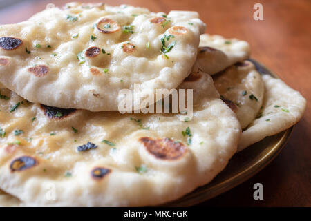 Just made homemade Naan bread stacked on a ceramic plate and sprinkled with cilantro Stock Photo