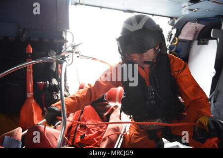 Petty Officer 1st Class Justin Cimbak, an aviation maintenance technician at Coast Guard Sector San Diego, readies the recovery basket for a hoist aboard an MH-60 Jayhawk helicopter during a joint search and rescue exercise with the Mexican navy off the coast of Ensenada, Mexico on June 7, 2017. The exercise simulated a vessel fire that required a coordinated international search and rescue effort. (U.S. Coast Guard photo by Petty Officer 3rd Class Joel Guzman) Stock Photo