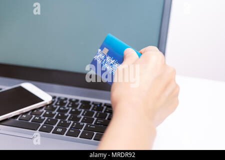 Hands holding credit card and using smart phone and laptop. Online shopping Stock Photo
