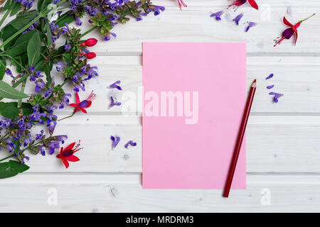 White tabletop with spring flowers, blank pink paper and a pencil Stock Photo