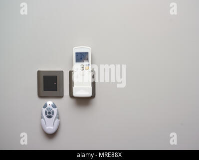 Various remote controls hanging on the wall, indoor closeup Stock Photo