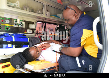 170610-N-CM227-181 Fire officers from the Bridgetown Fire Department assess and assist a volunteer actor during a mass casualty drill at the site of the former Glendairy Prison. The scenario was based on the idea that an earthquake caused a hotel to collapse and local emergency services and Barbados Defence Force (BDF) personnel were working together to rescue and treat survivors. Tradewinds 2017 Regional Observer and Assessment Team (ROAT) members from multiple countries watched the exercise to take notes and create an assessment for Barbadian officials. The report will contain ideas of ways  Stock Photo