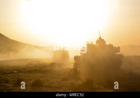 M1A2 Abrams Main Battle Tanks from 1st Battalion, 64th Armor Regiment continue their attack as the sun begins to set at the National Training Center at Fort Irwin, California April 13. The 1st Armored Brigade Combat Team, 3rd Infantry Division’s decisive action rotation at the National Training Center tested the brigade’s systems and capabilities as they fought a near-peer enemy threat. ( Stock Photo