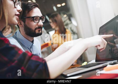 Bearded man and woman discussing marketing plan. Product meeting. Startup in open space office Stock Photo