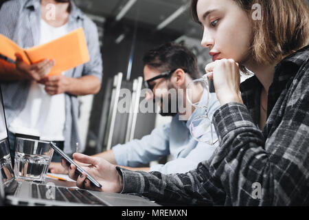 Photo of modern coworking people working in loft office with computers and laptops. Concept of work on digital devices. Team of creative managers thin Stock Photo