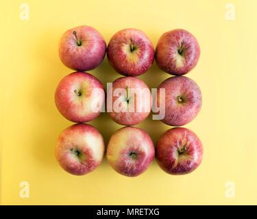 Red apples on yellow background. Stock Photo