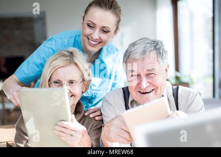 Senior couple using digital tablets in care home. Stock Photo