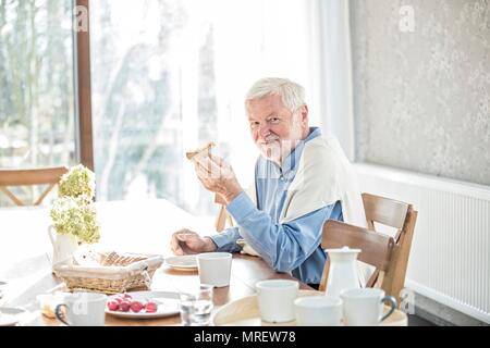 Senior man eating meal in care home. Stock Photo