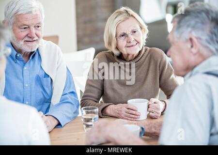 Friends talking in retirement home. Stock Photo