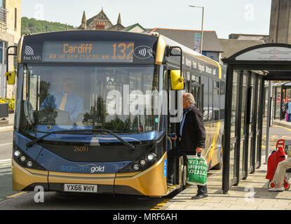 Passenger getting on a Stagecoach Gold public service bus at a bus stop in Pontypridd town centre Stock Photo