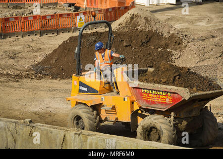 Construction worker driving a dumper full of earth on the site of a new office development in Pontypridd town centre Stock Photo
