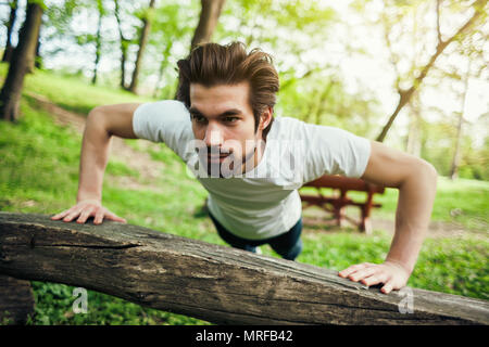 Young man is exercising. He is doing push-ups. Stock Photo