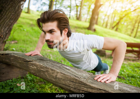 Young man is exercising. He is doing push-ups. Stock Photo
