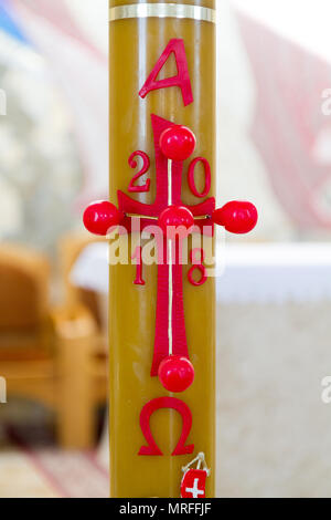 A 2018 Paschal candle (a large, white candle used in liturgies in blessed and lit every year at Easter, and is used throughout the Paschal season) Stock Photo