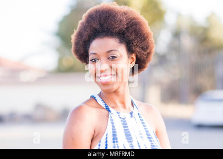 nice beautiful black race african model beautiful face and epression look at the camera. outdoor background portrait with natural light and joy Stock Photo