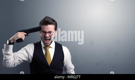 Young lost businessman man shooting his head with gun Stock Photo