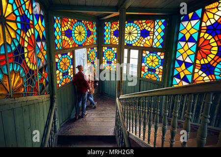 Romantic couple of tourist at balcony with stairs and colorful mosaic glasses in old Tbilisi, Georgia. Stock Photo