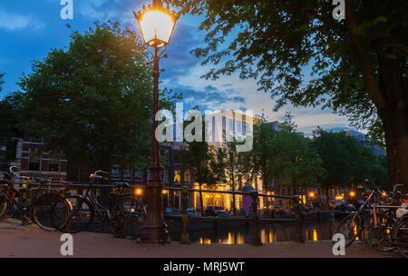 Traditional Dutch old houses on the canals in Amsterdam at night. Stock Photo