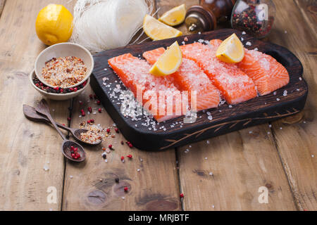 Raw salmon fillet with pepper sweetbread and salt on baking paper rustic theme with copy-space. Stock Photo