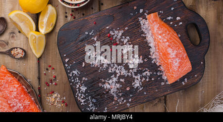 Raw salmon fillet with pepper sweetbread and salt on baking paper rustic theme with copy-space. Flat lay Stock Photo