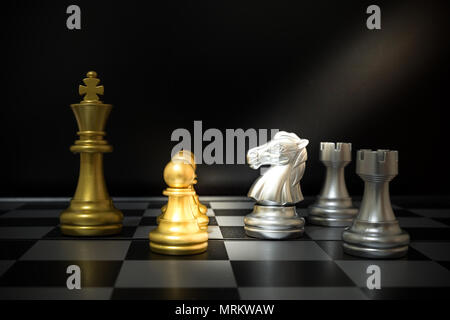 The white horse in the game on the chess board has an advantageous movement, the opponent is a golden rival. Stock Photo