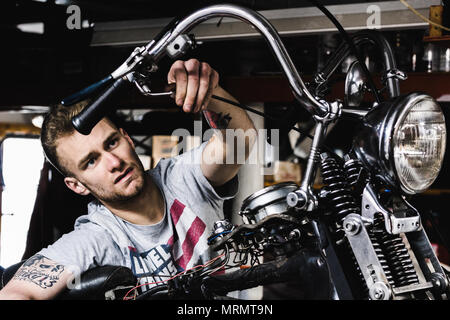 A mechanic working on his motorcycle Stock Photo