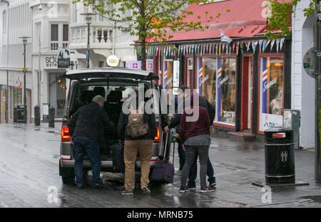 Laugavegur, Reykjavík, Iceland. 26/05/2018. Yellow warning for bad weather on the island as tourists from cruise ships and foreign holidaymakers visit the shops, in the tourist section of the city centre. A day of windy, persistent continuing heavy rain is forecast. Credit: ConradElias/AlamyLiveNews Stock Photo