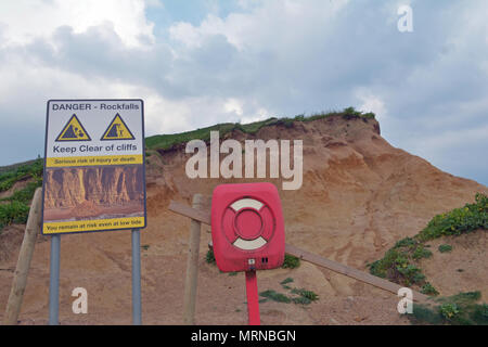 Dorset, UK. 26 May 2018. May Bank Holiday Weekend. Alone person stands on top of Dangerous Cliffs at West Bay in Dorset where in the past parts of the Famous cliff face have given way. Warning Signs have been put in place since stating the Dangers but still people put themselves at risk and others beneath. Robert Timoney/Alamy/Live/News