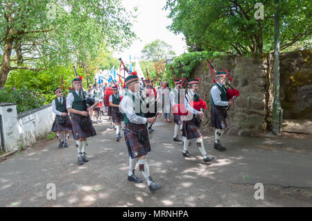 Glasgow , Scotland, UK. 27th May, 2018. St. Francis Pipe Band playing during the street procession of the Carmunnock International Highland Games which celebrates traditional Scottish culture with a Chieftain and athletes, heavy events including stone putt, challenge caber & sheaf pitch, other events include log boxing, stick fighting & wrestling, music events include Eaglesham Fiddlers,and Highland Dancing and is held in the picturesque conservation village of Carmunnock. Credit: Skully/Alamy Live News Stock Photo