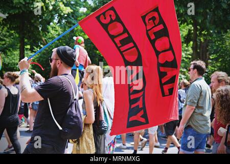 A man seen waving a flag writting on it 'Global Solidarity' during the protest. Techno lovers and anti racism activists have marched in Berlin against a rally organised by the German far-right party, AFD. Over 70.000 people (according to the organisers) have taken the streets of Berlin with a huge party organised by some of the most famous Berlin techno clubs. Several counter demos have taken place along the German capital to protest against the AFD rally that has started at the main train station and finished at the Brandenburger Tor with hundreds of attendants. Stock Photo