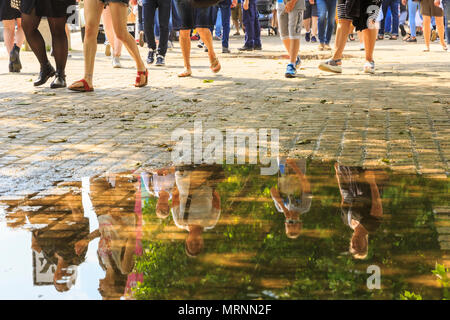 South Bank, London, 27th May 2018. The warm sunshine brings out crowds of Londoners and tourists for a stroll along the South Bank on the River Thames, which still has puddles of rainwater from last night's storm. Following a night with heavy thunder storms and torrential rain, London has seen warm, humid temperatures and sunshine on the Bank Holiday Sunday. Stock Photo