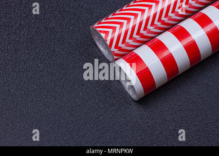 Rolls of gift wrapping paper on a black background with space for text Stock Photo