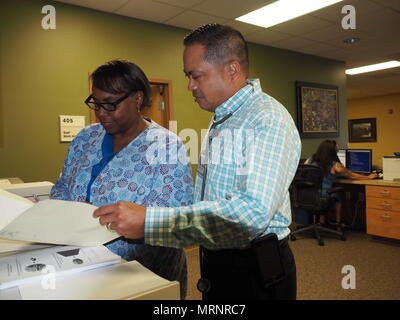 Community Based Outpatient Clinic nurse manager is a healthcare administrator overseeing clinical operations within the Department of Veterans Affairs system. A nurse manager reviews clinic performance metrics with a medical officer at the Spartanburg Community Based Outpatient Clinic associated with the Dorn VA Medical Center. The archival image documents administrative healthcare coordination within a federal veterans medical facility. Stock Photo