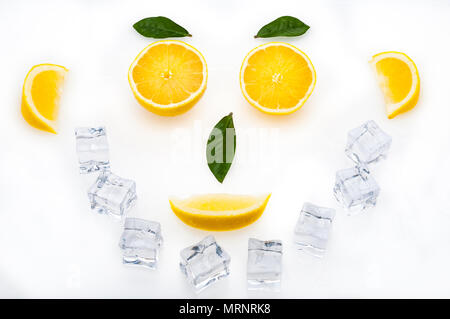 Bright lemon slices, green leaves and ice cubes in the shape of a face. healthy lifestyle. Stock Photo