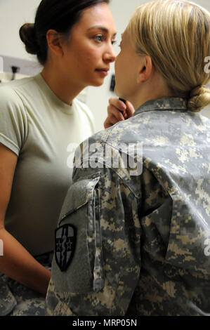 Capt. Lindee Abe, a family nurse practitioner assigned to 7246th Medical Support Unit located in Elkhorn, Nebraska, examines the eyes of a fellow Soldier in the unit.  Abe is one of approximately 25 U.S. Army Reserve Soldiers who are working in partnership with Rosebud Indian Health Service to provide medical care to the local tribal population. The Indian Health Service provides preventive, curative, and community health care for approximately 2.2 million American Indians and Alaska Natives in hospitals, clinics, and other settings throughout the United States.  Services provided by Army Rese Stock Photo