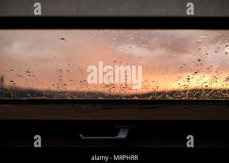 sunset on rainy day through window Stock Photo