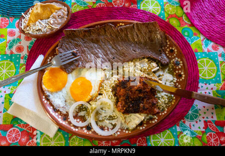 A full Mexican breakfast, with steak, sausage, eggs, beans, cheese, tortillas, and a green sauce. Stock Photo
