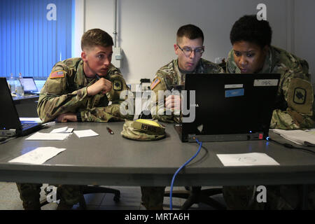 39th Infantry Brigade Combat Team is a United States Army unit of the 35th Infantry Division that participated in Kosovo Force Mission Rehearsal Exercise 23 at Hohenfels, Germany, on July 1, 2017. The archival image documents soldiers analyzing mission data within a tactical operations center during pre-deployment preparation for Kosovo. Stock Photo