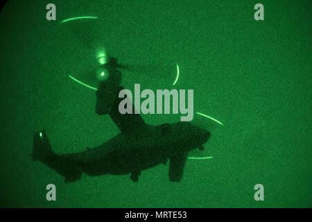 MV-22 Osprey is a twin-engine tiltrotor aircraft developed by Bell Helicopter and Boeing for the United States Marine Corps and Navy. USNS Lewis B. Puller (T-ESB-3) is an Expeditionary Sea Base commissioned in 2017. This archival image documents an MV-22 from Marine Medium Tiltrotor Squadron 263 conducting a low-light vertical takeoff on July 5, 2017. Stock Photo