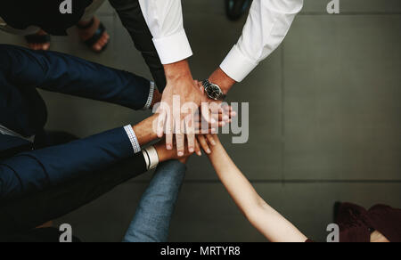 Unity and teamwork Concept. Top view of business people putting their hand together. Stock Photo