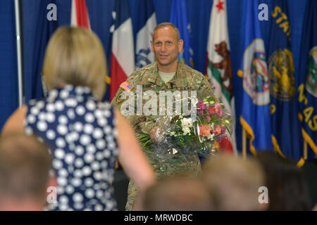 U.S. Army Brig. Gen. Donald C. Bolduc, outgoing commander of Special Operations Command Africa, presents his wife with flowers during a ceremony which at Kelley Barracks, Stuttgart, Germany, June 29, 2017. (U.S. Army photo by Visual Information Specialist Jason Johnston.) Stock Photo