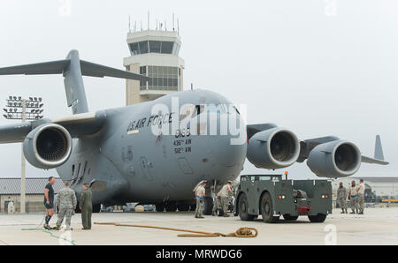 Aircraft maintenance personnel from the 712th and 736th Aircraft Maintenance Squadrons reposition a C-17 Globemaster III for Cmdr. Grant Edwards, Australian Federal Police, Embassy of Australia, Washington, D.C., for his second attempt at pulling the aircraft weighing approximately 418,898 pounds, June 16, 2017, on Dover Air Force Base, Del. Edwards is scheduled to attempt pulling a C-17 during the “Thunder Over Dover: 2017 Dover AFB Open House,” Aug. 26-27. (U.S. Air Force photo by Roland Balik) Stock Photo